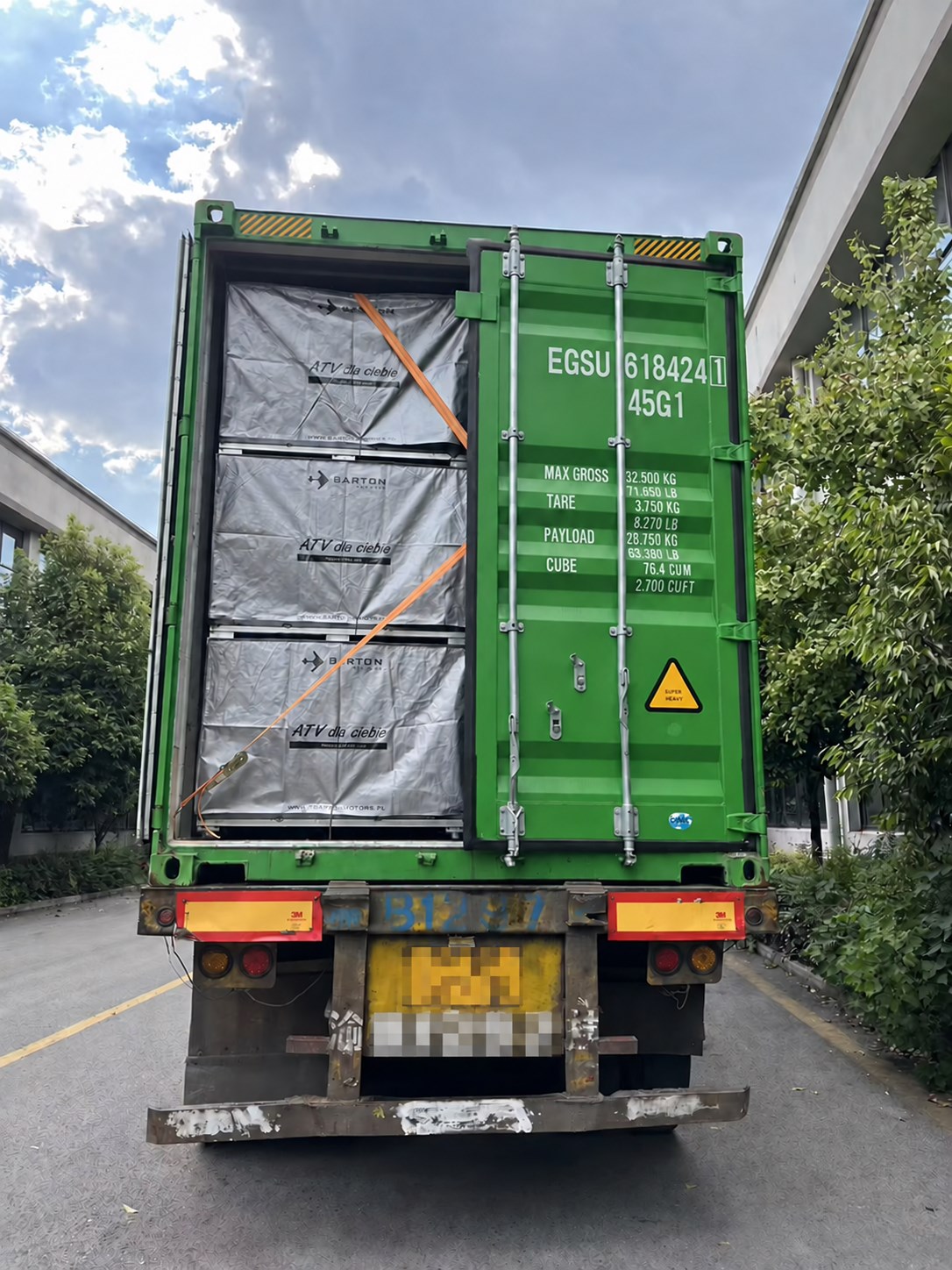 Container loading for a private-label ATV shipment, with the vehicle license plate obscured for privacy
